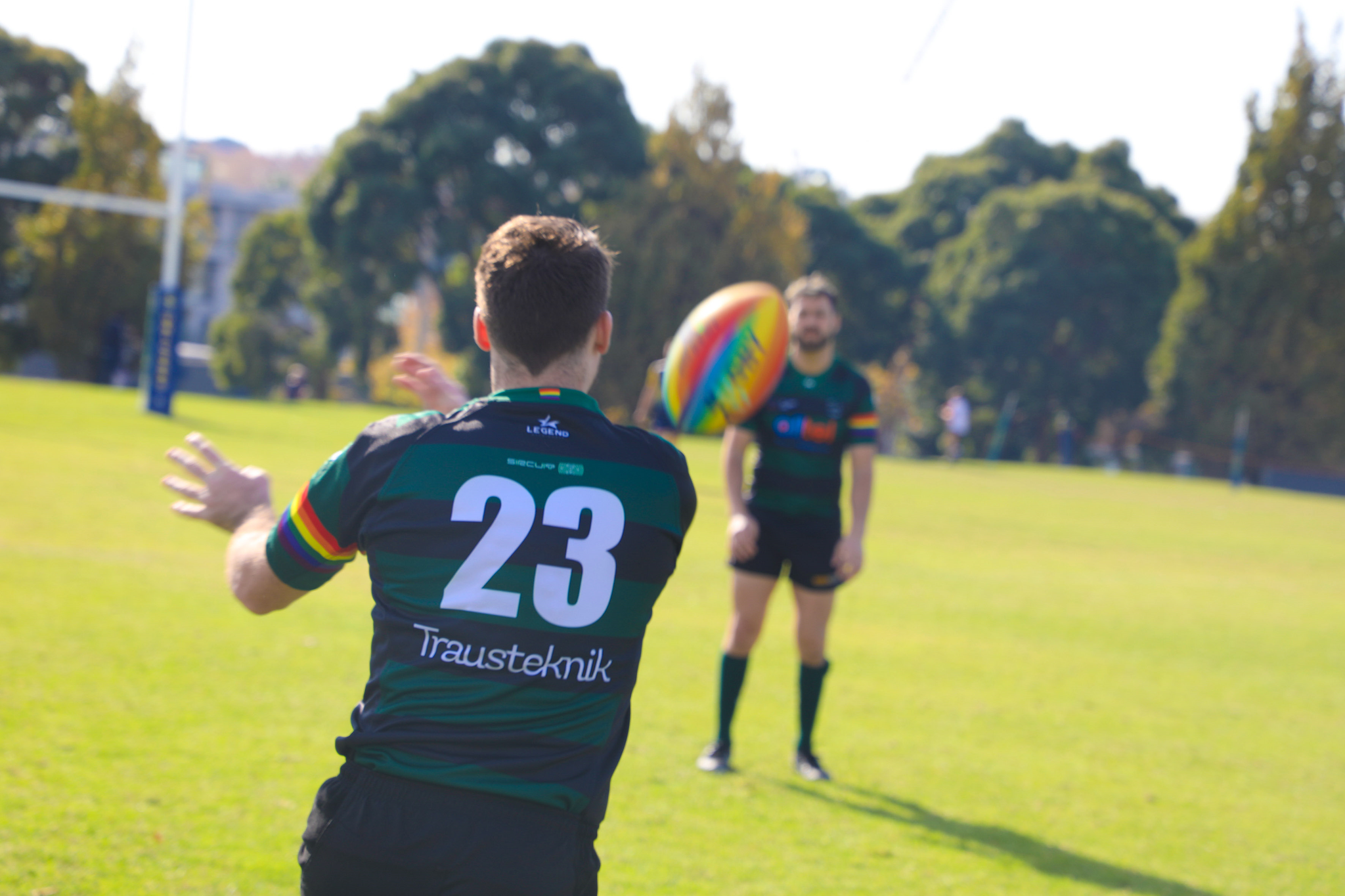 An Image of Melbourne Chargers Players passing a rainbow rugby ball.